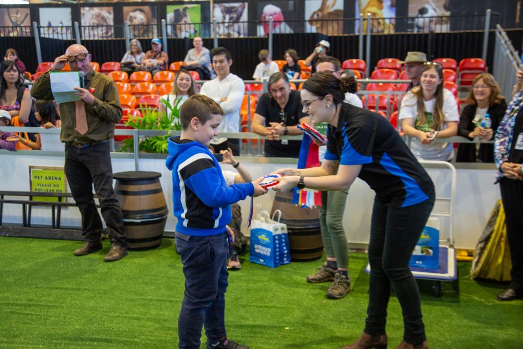 Vetafarm employee presenting an award to a boy.